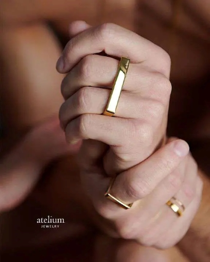 large ad of mans hands wearing gold rings